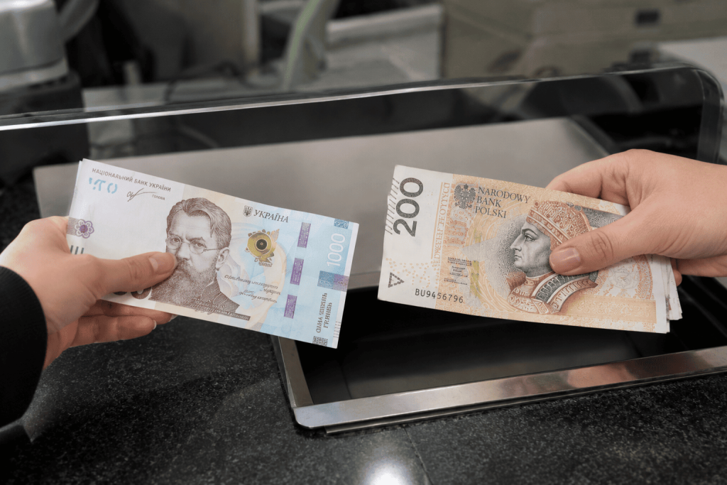 Wymiana hrywien na złotówki w kantorze Argentarii – banknoty UAH i PLN przekazywane z rąk do rąk